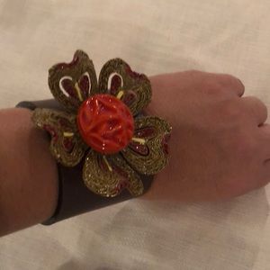 Leather cuff with floral brooch